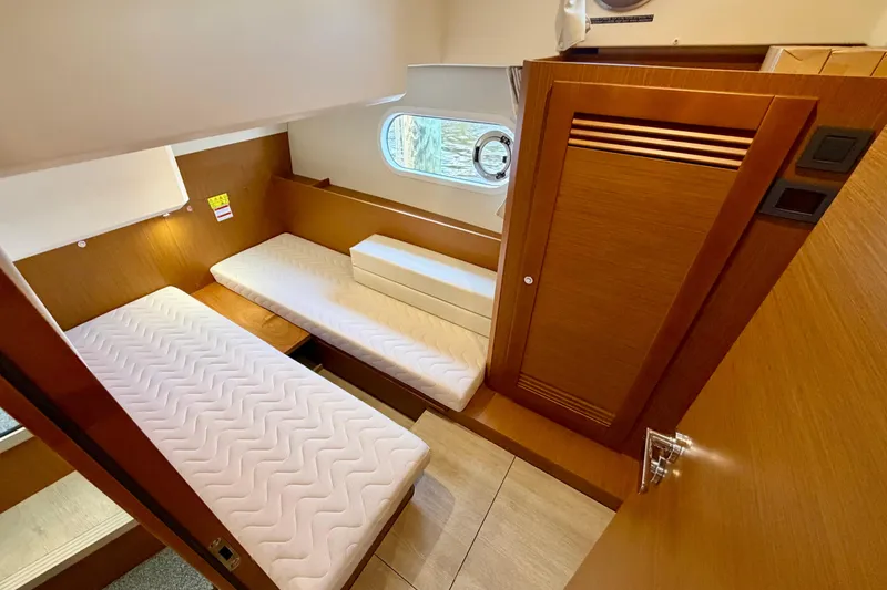 Slide: The Image of 2025 Beneteau Swift Trawler 41 Fly cabin interior with twin beds and wooden finish. - 30