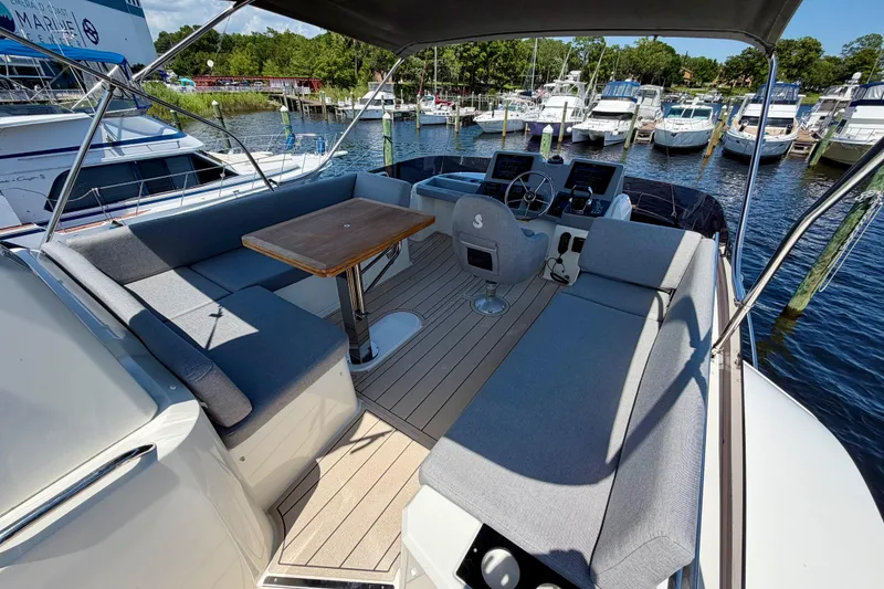Slide: The Image of 2025 Beneteau Swift Trawler 41 Flybridge with seating and helm, docked at marina. - 13