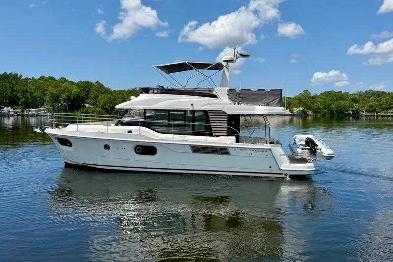 Slide: The Image of 2025 Beneteau Swift Trawler 41 Fly on a serene lake under a clear blue sky. - 5