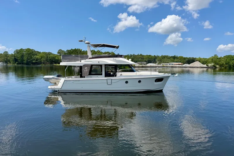 Slide: The Image of 2025 Beneteau Swift Trawler 41 Fly on calm water under blue sky. - 4