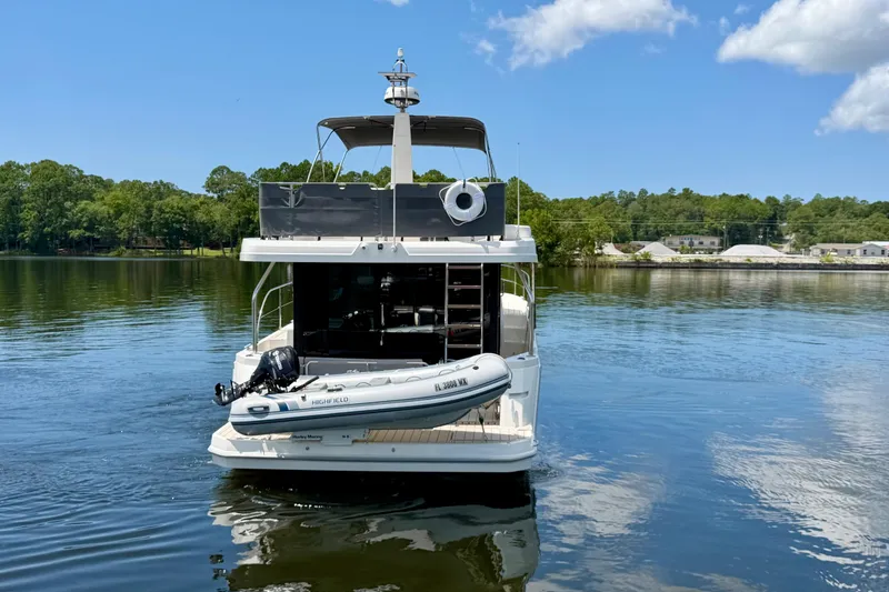 Slide: The Image of 2025 Beneteau Swift Trawler 41 Fly on serene lake with inflatable boat. - 3