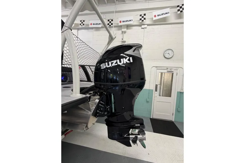Slide: The Image of Outboard motor on a 2026 South Bay 525SB2 boat in a Suzuki showroom. - 10