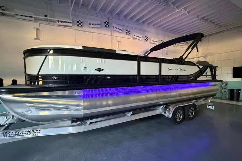 Slide: The Image of 2026 South Bay 525SB2 pontoon boat with trailer, displayed indoors. - 29
