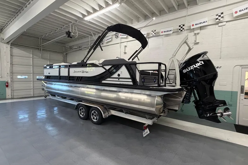 Slide: The Image of 2026 South Bay 525SB2 pontoon boat with Suzuki engine in a showroom. - 3