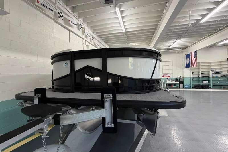 Slide: The Image of 2026 South Bay 525SB2 pontoon boat in a showroom with flags and banners. - 5