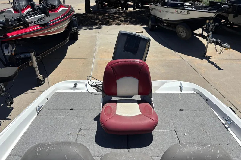 Slide: The Image of 1998 Nitro 700 LX DC boat with red seat, parked among other boats. - 6