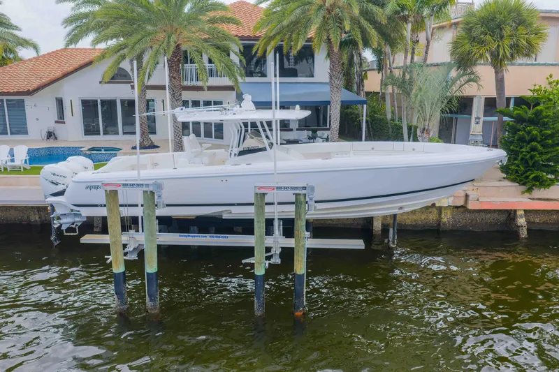 Slide: The Image of 2019 Intrepid 400 Center Console boat docked near waterfront home. - 4