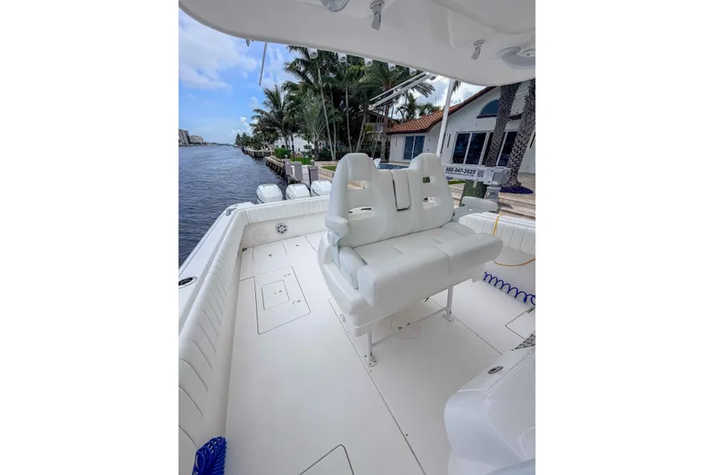 Slide: The Image of 2019 Intrepid 400 Center Console boat interior with white seating and waterfront view. - 23