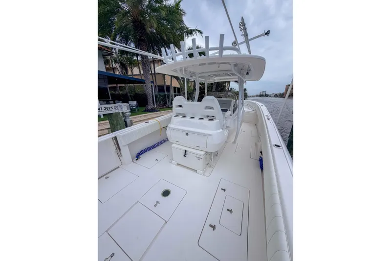 Slide: The Image of 2019 Intrepid 400 Center Console boat with spacious deck and seating, docked near palm trees. - 19