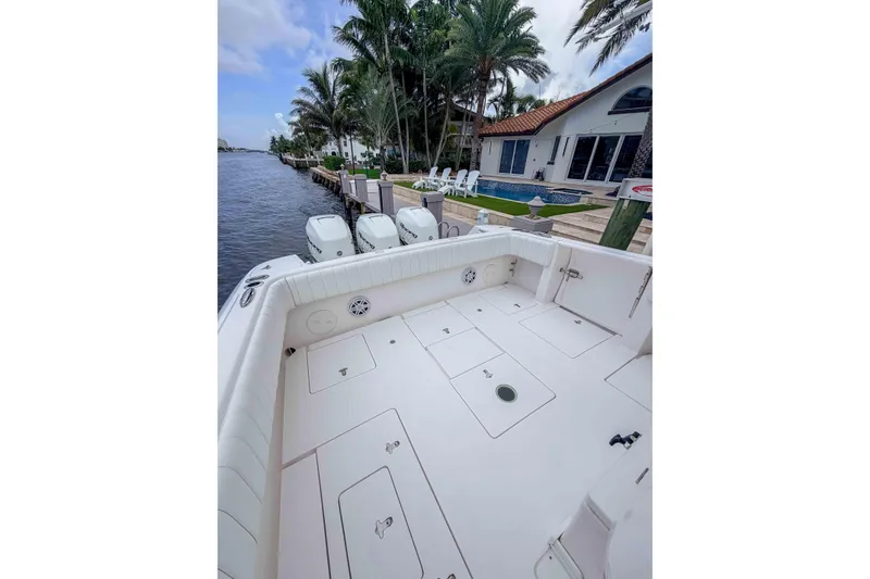 Slide: The Image of 2019 Intrepid 400 Center Console boat docked by waterfront home with palm trees. - 29