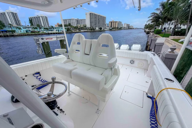 Slide: The Image of 2019 Intrepid 400 Center Console boat with white seating, docked by waterfront buildings. - 26