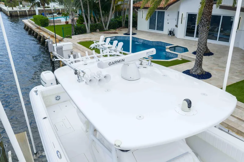 Slide: The Image of 2019 Intrepid 400 Center Console boat docked near a luxurious waterfront property. - 14