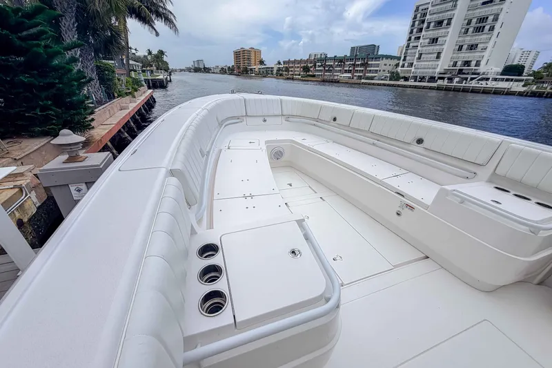 Slide: The Image of 2019 Intrepid 400 Center Console boat with spacious seating, docked by waterfront buildings. - 38