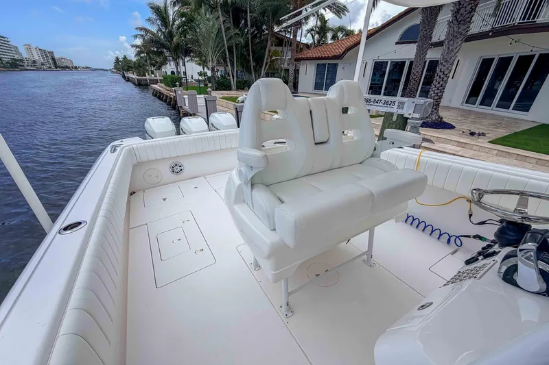 Slide: The Image of 2019 Intrepid 400 Center Console boat with white seating, docked by a waterfront property. - 24