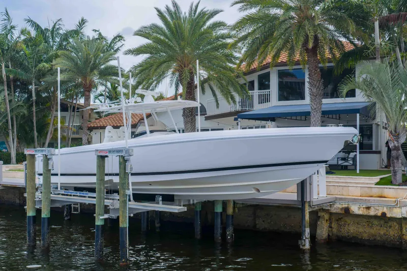 Slide: The Image of 2019 Intrepid 400 Center Console boat docked near tropical waterfront home. - 3