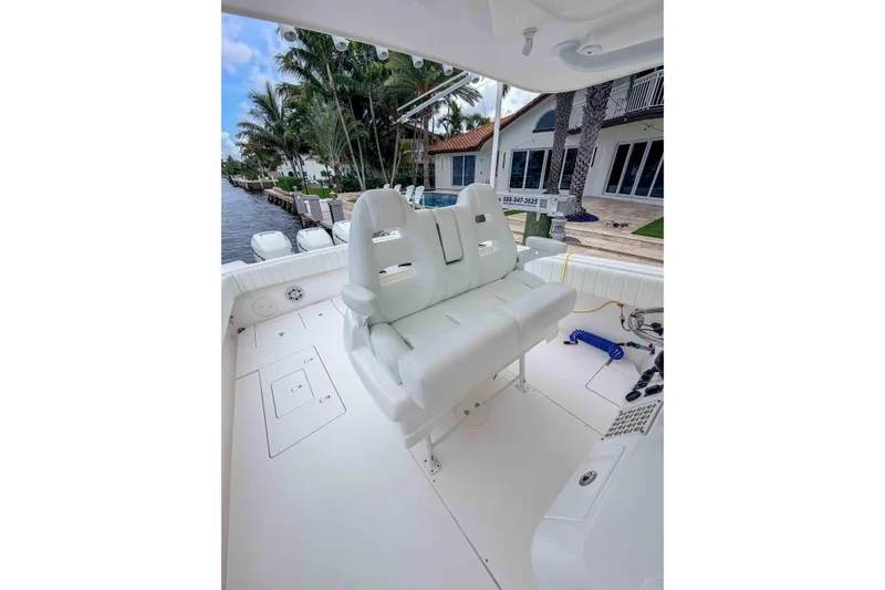 Slide: The Image of 2019 Intrepid 400 Center Console boat interior with white seating and waterfront view. - 27