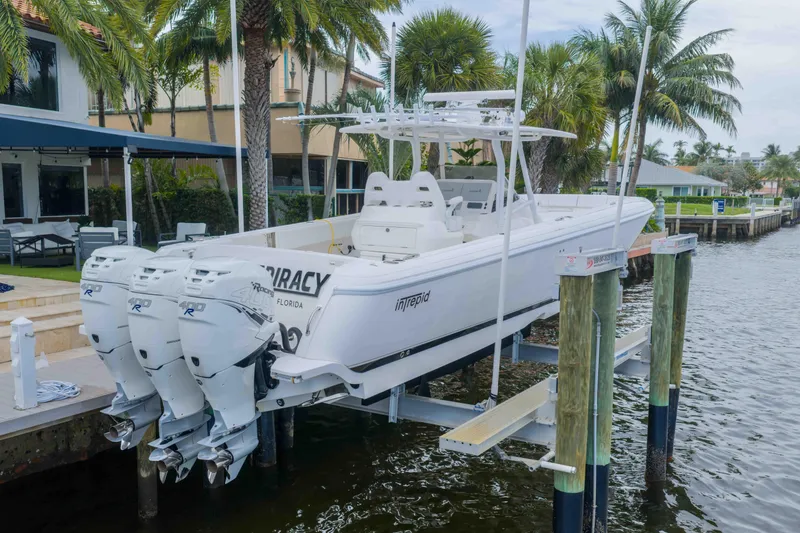 Slide: The Image of 2019 Intrepid 400 Center Console boat docked by waterfront home with palm trees. - 6