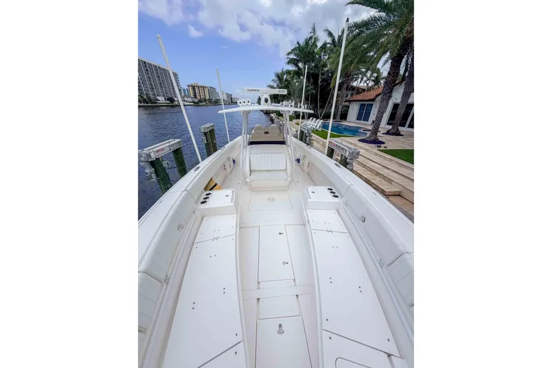 Slide: The Image of 2019 Intrepid 400 Center Console boat docked by waterfront homes and palm trees. - 40