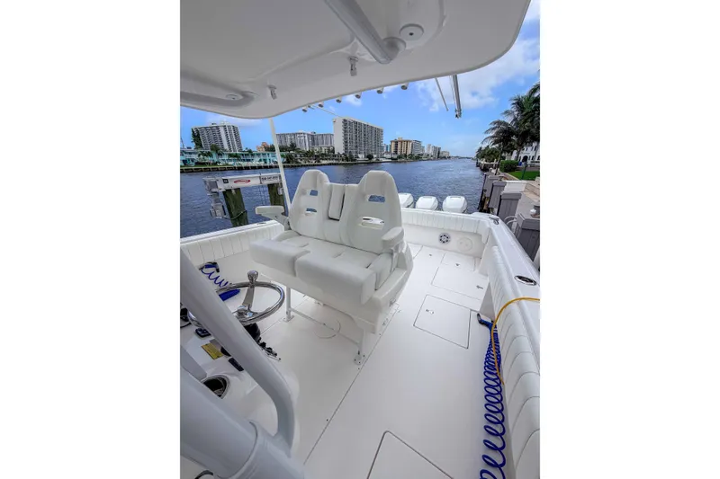 Slide: The Image of 2019 Intrepid 400 Center Console boat interior with seating, docked by waterfront buildings. - 25
