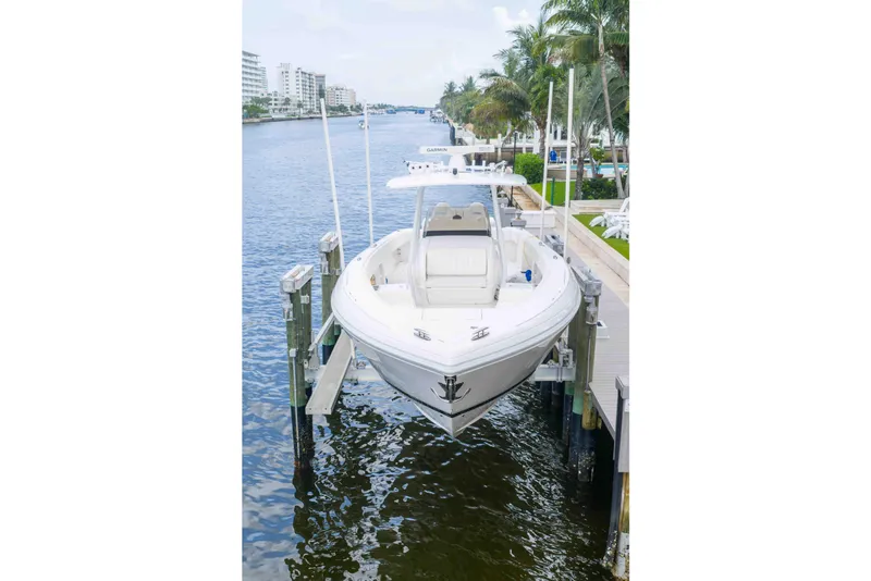 Slide: The Image of 2019 Intrepid 400 Center Console boat docked by waterfront homes. - 8