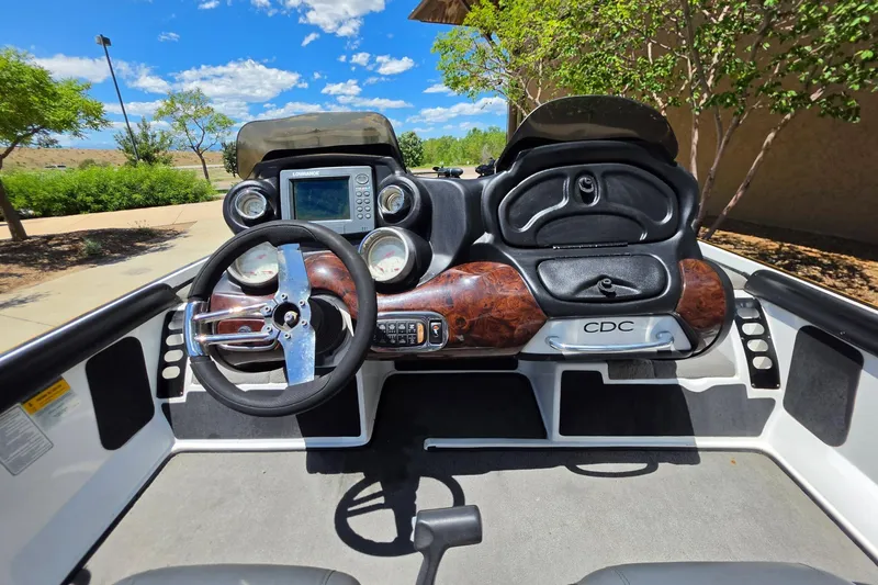 Slide: The Image of 2008 Nitro Z-9 boat dashboard with steering wheel and navigation system under a clear blue sky. - 2