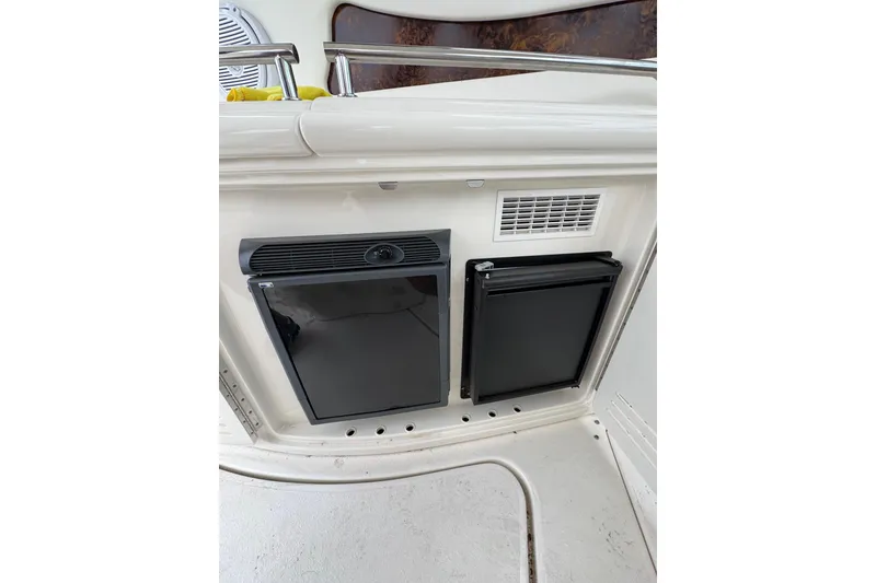 Slide: The Image of 2003 Sea Ray 550 Sundancer interior with built-in mini fridge and storage compartment. - 16