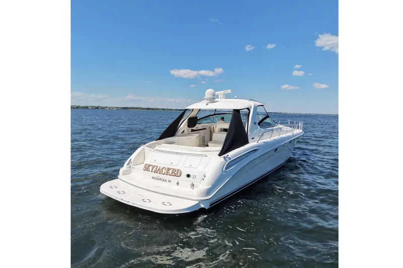 Slide: The Image of 2003 Sea Ray 550 Sundancer yacht on open water under clear blue sky. - 2