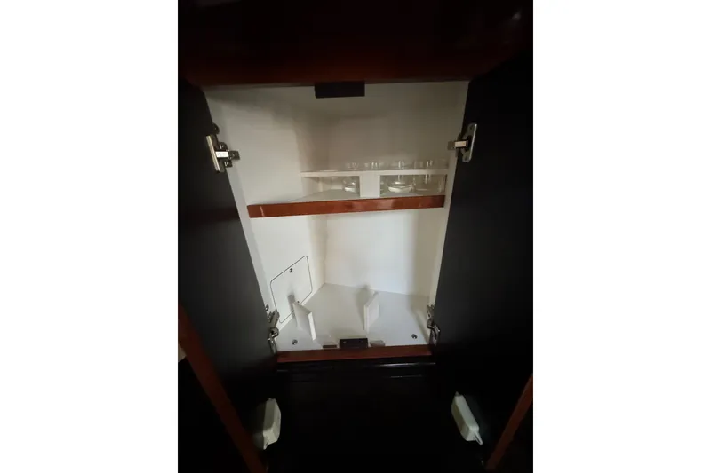Slide: The Image of Open cabinet interior on 2003 Sea Ray 550 Sundancer yacht, featuring shelves and storage space. - 38