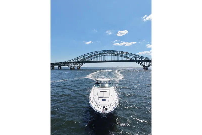 Slide: The Image of 2003 Sea Ray 550 Sundancer cruising under a bridge on a sunny day. - 3