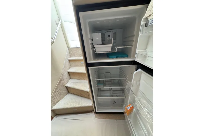 Slide: The Image of Open refrigerator inside 2003 Sea Ray 550 Sundancer yacht, near carpeted stairs. - 41
