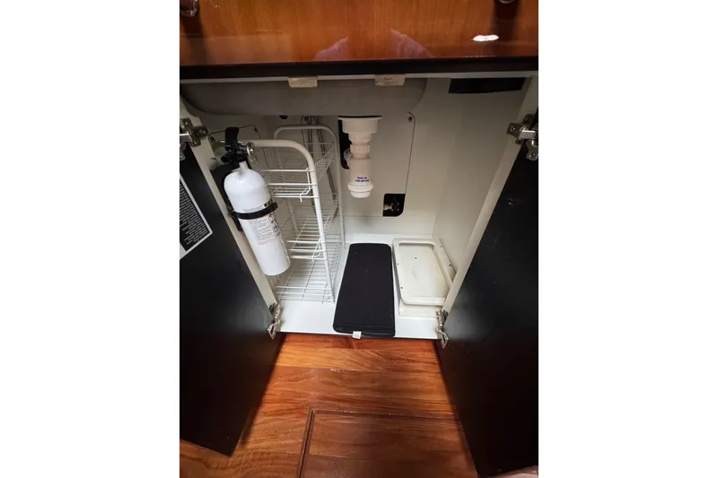 Slide: The Image of Open cabinet in 2003 Sea Ray 550 Sundancer with fire extinguisher and storage shelves. - 26