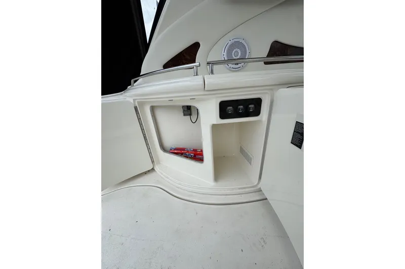 Slide: The Image of Open storage compartment on 2003 Sea Ray 550 Sundancer yacht with control panel and speaker. - 17
