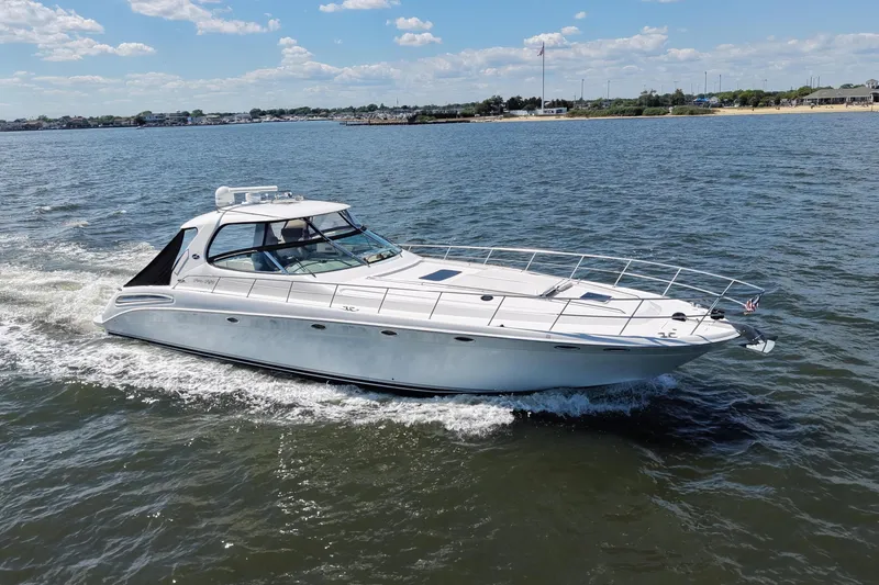 Slide: The Image of 2003 Sea Ray 550 Sundancer cruising on open water under a clear blue sky. - 4