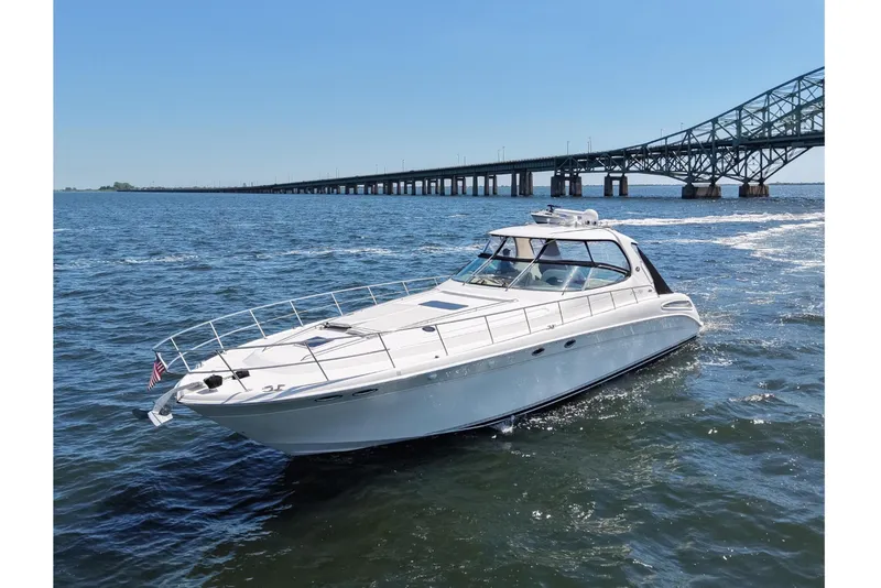 Slide: The Image of 2003 Sea Ray 550 Sundancer yacht cruising near a bridge on a sunny day. - 5