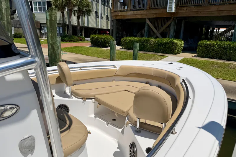 Slide: The Image of 2016 Sportsman Heritage 211 Center Console boat with beige seating, docked near waterfront homes. - 6