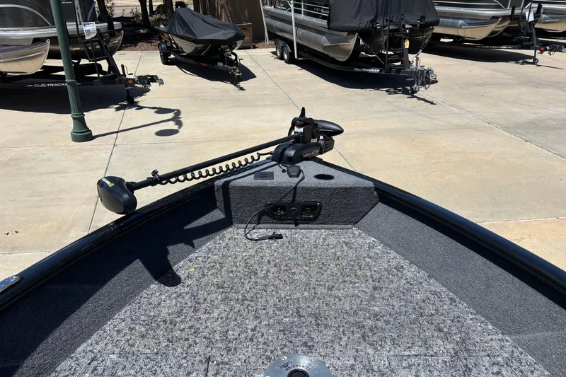 Slide: The Image of 2025 Tracker Pro Guide V-175 Combo boat with trolling motor in a parking area. - 5