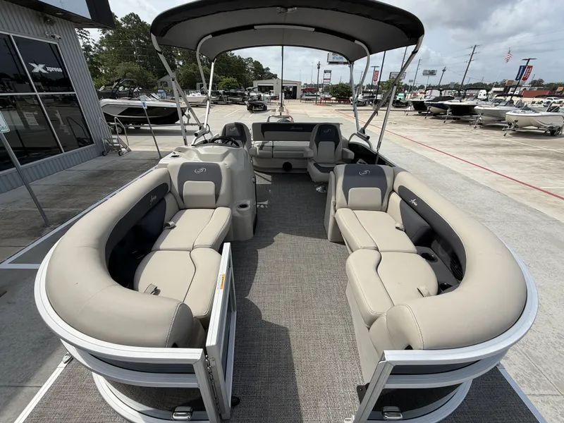Slide: The Image of The image shows a 2024 Barletta A20UC pontoon boat with beige seating and a Bimini top. - 10