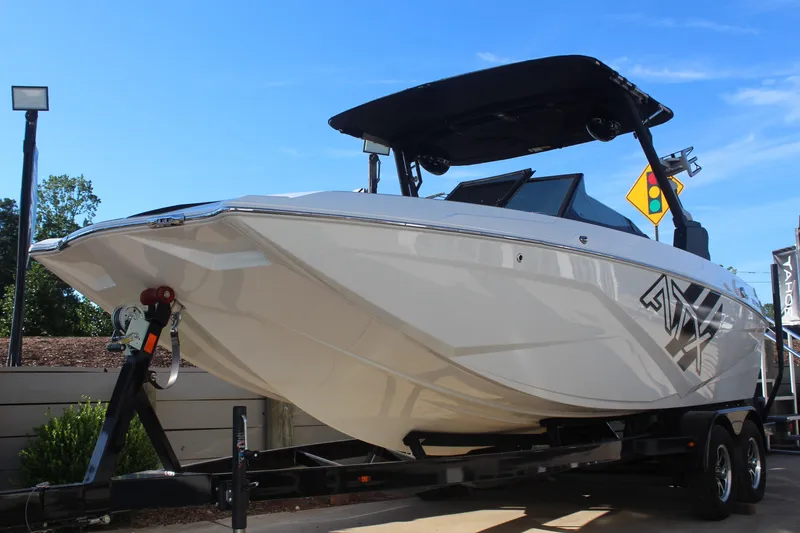 Slide: The Image of 2024 ATX Surf Boats 22 Type-S on trailer, sleek design, white exterior, sunny day. - 6