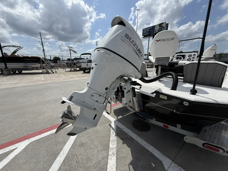 Slide: The Image of A 2022 Vexus AVX1980CC boat with a Suzuki outboard motor, parked on a concrete lot. - 10