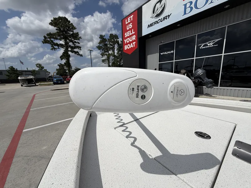 Slide: The Image of Close-up of a boat deck with a white device. Building with boat signs in the background. - 5