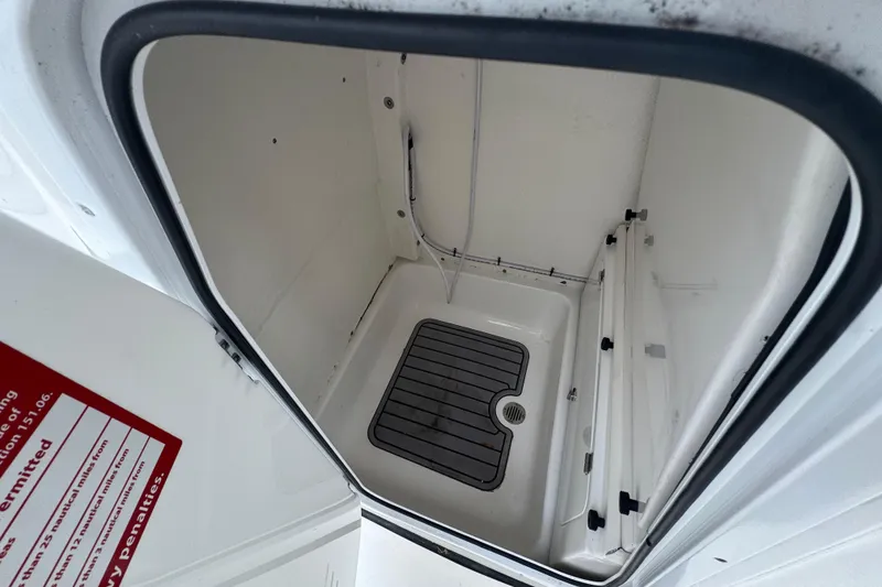 Slide: The Image of Interior storage compartment of 2022 Tidewater 232 SS boat, featuring a drain and non-slip mat. - 11