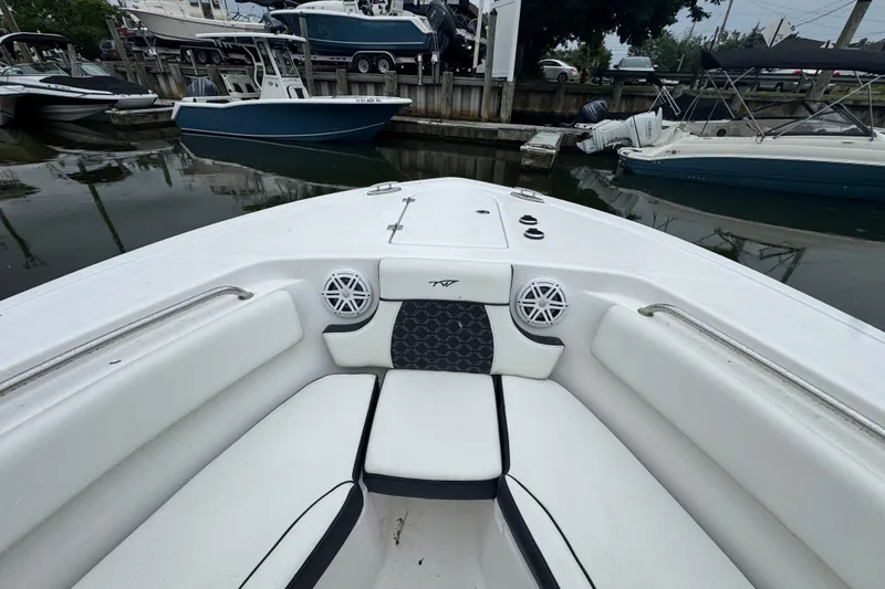 Slide: The Image of 2022 Tidewater 232 SS boat interior with seating and speakers at a marina. - 13
