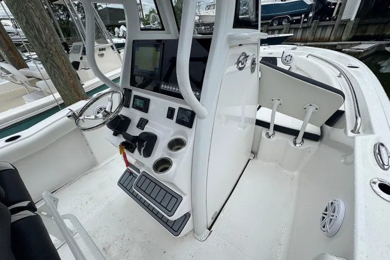 Slide: The Image of 2022 Tidewater 232 SS boat interior with steering console and seating area. - 19