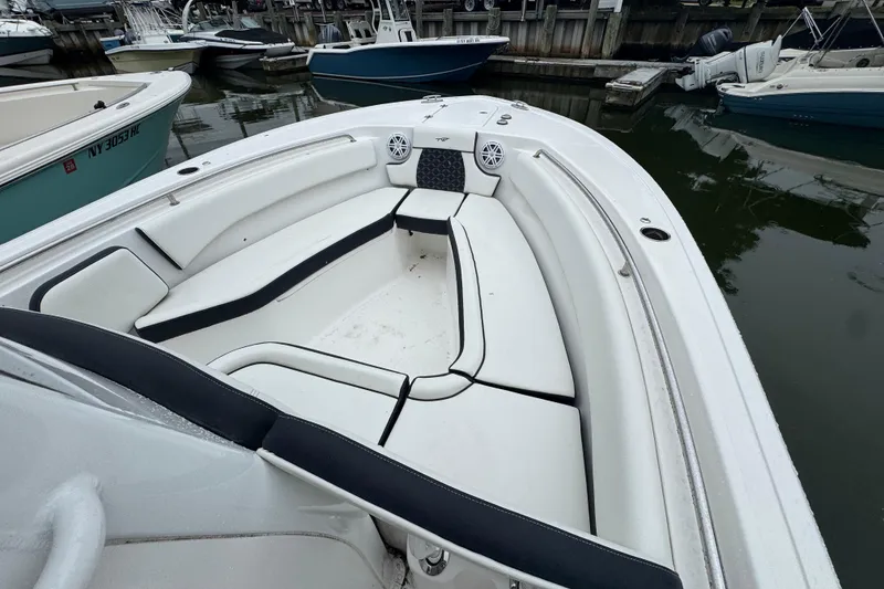 Slide: The Image of 2022 Tidewater 232 SS boat with spacious white seating at a marina. - 20