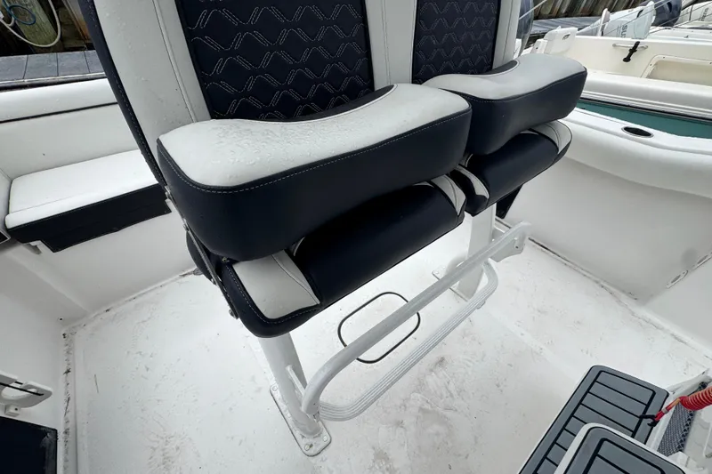 Slide: The Image of 2022 Tidewater 232 SS boat interior with dual cushioned seats and sleek design. - 8
