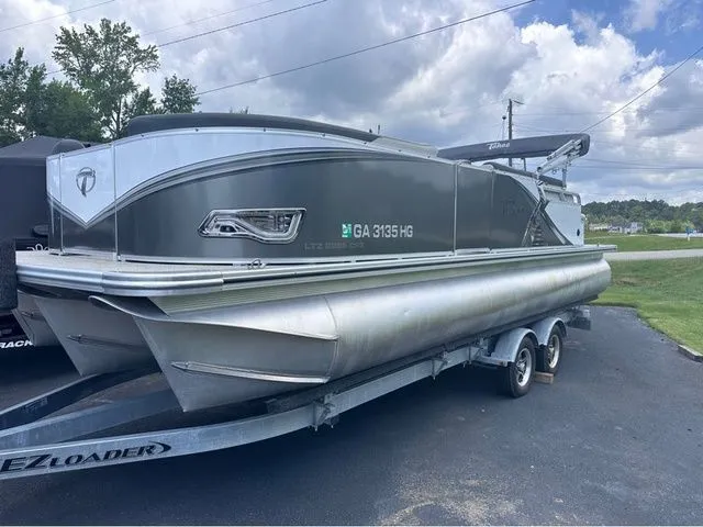 The Image of A 2021 Tahoe LTZ Cruise Rear Bench 24' pontoon boat on a trailer, ready for the water. - 1