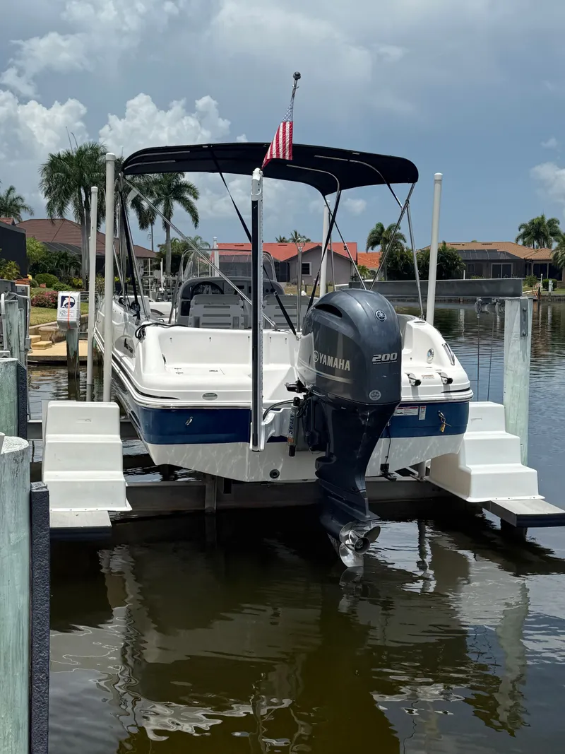 Slide: The Image of A 2022 Hurricane 231 SS boat on a lift, featuring a Yamaha outboard motor. - 0