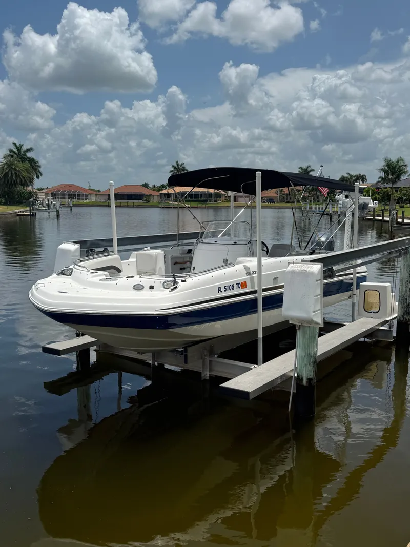 The Image of A 2022 Hurricane 231 SS boat on a lift by a calm waterway. - 1
