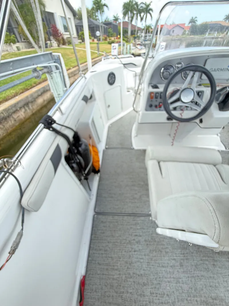 Slide: The Image of The image shows the cockpit of a 2022 Hurricane 231 SS boat with white seats and a helm. - 12