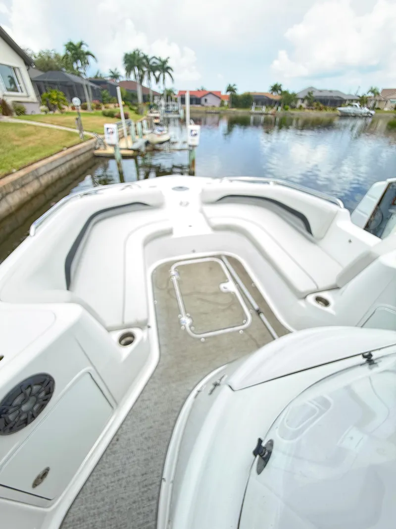 Slide: The Image of The boat features a spacious deck with seating, situated in a calm harbor. - 13